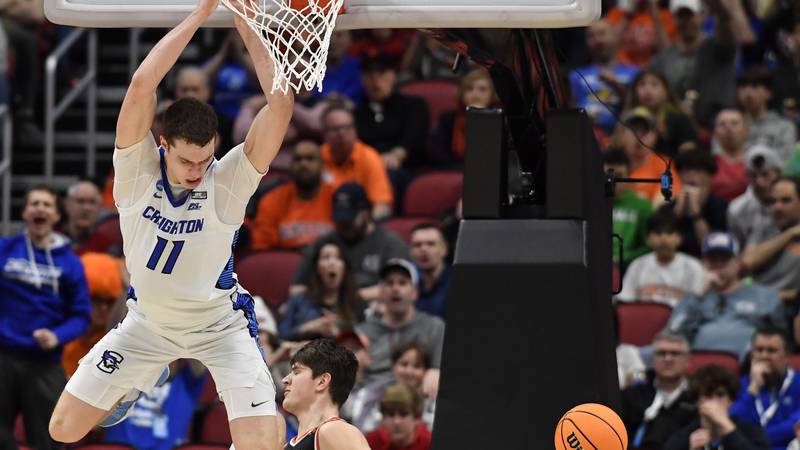 Creighton center Ryan Kalkbrenner (11) hangs from the rim after a dunk against Princeton...